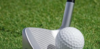 close up of a golf chipper near a golf ball
